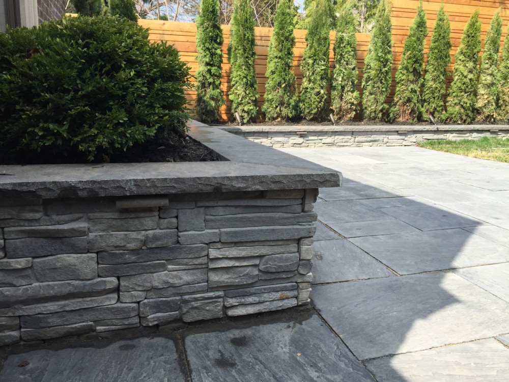 stone retaining wall, boxwood, cedars, permacon